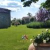 Farmhouse with panoramic Val d'Orci landscape and lush garden setting.