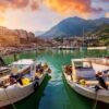Boats docked at a scenic harbor in Santo Stefano di Camastra with colorful buildings and mountains i.