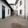 View of a quiet alley between white residential buildings in Fino Mornasco, Lake Como, Italy.