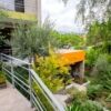 Modern glass house with lush garden and outdoor seating in San Miguel de Allende, Mexico.