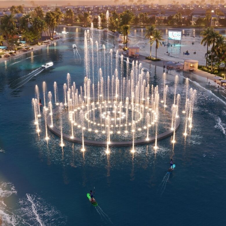 Dubai fountain with illuminated water jets and palm trees at sunset.