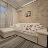 Apartment with white leather sofa and decorative pillows in a modern living room.