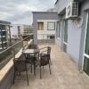 Spacious balcony with seating overlooking cityscape.