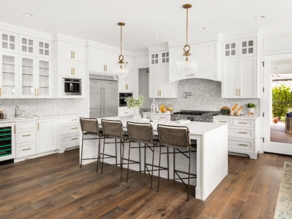 Bright, spacious kitchen featuring a large island, white cabinetry, and modern appliances for functi.