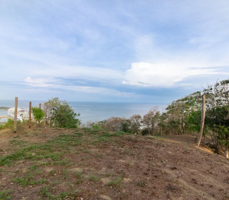Ocean view land for sale with scenic coastal landscape and clear blue sky.