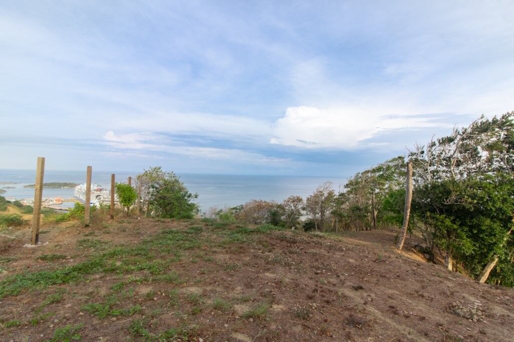 Ocean view land for sale with scenic coastal landscape and clear blue sky.