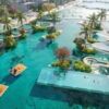 Stunning tropical resort with a large pool, water slides, and lush landscaping, perfect for relaxati.
