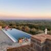 Luxury villa with infinity pool overlooking Tuscany landscape.