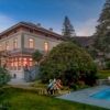 Luxury villa with swimming pool overlooking Lake Maggiore, surrounded by lush gardens and scenic mou.