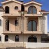 Elegant residential building with arched windows and balconies.
