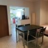 Bright apartment with dining table, kitchen, and bedroom in Beja, Portugal.