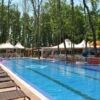 Outdoor swimming pool at Tarsis - Club & Spa, Sunny Beach, surrounded by lush trees.