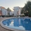 Pool view of a modern one-bedroom apartment complex in Sunny Beach, Bulgaria, with outdoor swimming.