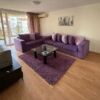 Bright living room with purple sofa, glass coffee table, and balcony view in Nessebar Fort club.