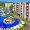 Beautiful pool view of Cascadas Family Resort in Sunny Beach, featuring sun loungers and lush greene.