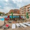 Bright poolside view of Sunny Day 6 with sun loungers and umbrellas. Perfect for relaxing in this af.