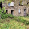 Small stone house in need of renovation with two gardens and surrounding greenery.