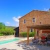 Renovated stone barn with pool, outdoor seating, and lush garden setting.