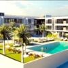 Modern apartments in Fuseta with a large swimming pool and tropical palm trees.