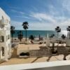 Beachfront view of Quarteira with palm trees and ocean scenery.