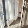 Bright room featuring expansive windows and a balcony, offering excellent natural light and a welcom.