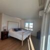 Bright bedroom with large window and modern furnishings.