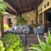 Luxury Bali villa outdoor lounge with comfortable seating and lush greenery.