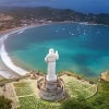 Scenic view of Rivas Bay with a statue overlooking the coastline and ocean.
