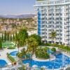 Modern coastal resort with swimming pools, lush gardens, and scenic mountain views in Gazipasa.