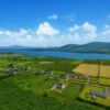 Beautiful aerial view of a modern 4-bedroom home on Valentia Island, overlooking lush green fields a.
