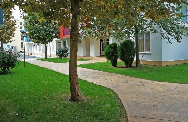 Green outdoor area with trees and pathways in Sunny Day 3 residential complex.