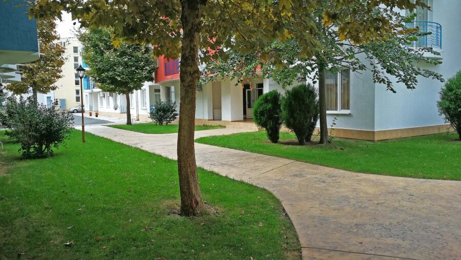 Green outdoor area with trees and pathways in Sunny Day 3 residential complex.