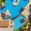 Beautiful aerial view of the Coral Resort swimming pool with shaded cabanas and sun loungers.