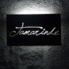 Tamarinde bed and breakfast sign on a textured wall in The Gambia.