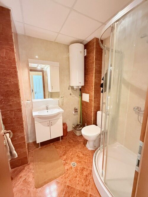 Bright bathroom with shower, toilet, and sink in holiday studio at Sunny Fort Club.