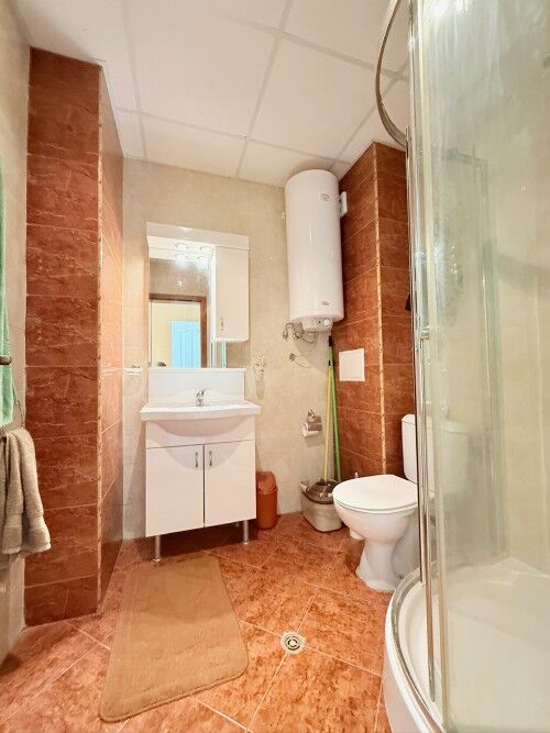 Bright bathroom featuring a shower, toilet, and sink with mirror in Holiday Fort Club.