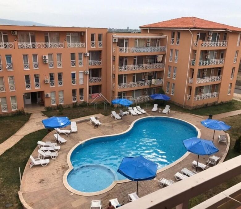 Apartment complex with a pool, sun loungers, and umbrellas in Sunny Day 6, Sunny Beach.