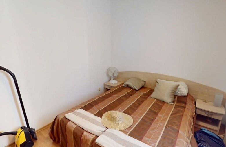 Bright bedroom with double bed and pillows in a central Sunny Beach apartment.