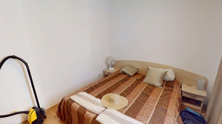 Bright bedroom with double bed and pillows in a central Sunny Beach apartment.