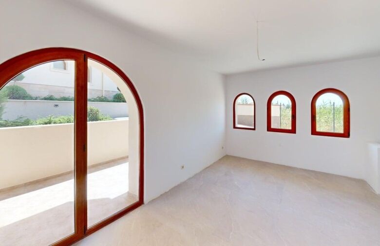 Bright interior with large arched windows and balcony access.