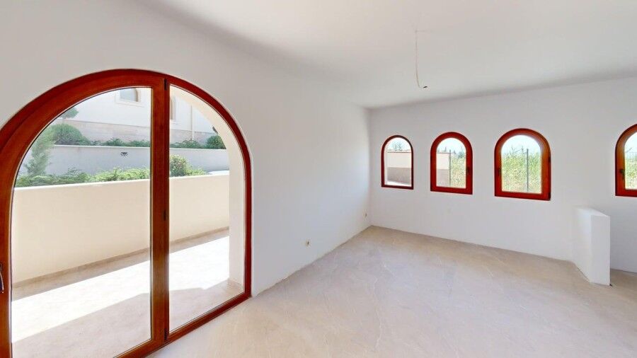 Bright interior with large arched windows and balcony access.
