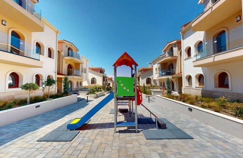 Colorful playground in a modern residential community near the sea.