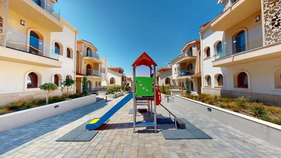 Colorful playground in a modern residential community near the sea.