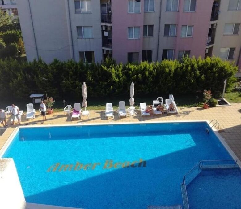 Amber Beach pool with sun loungers and umbrellas in Sunny Beach resort.