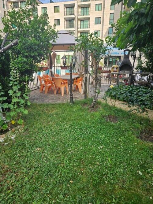 Garden with outdoor dining and greenery at Amber Beach resort in Sunny Beach.