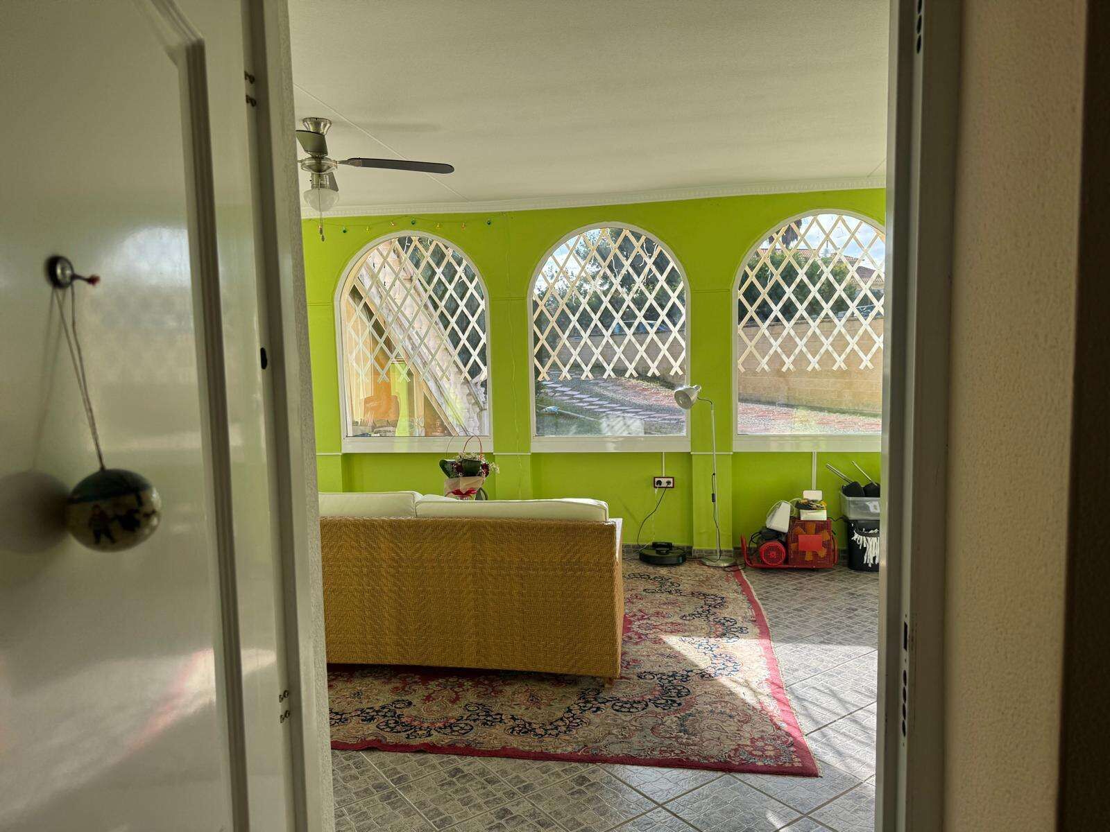 Spacious living room with large arched windows and vibrant green walls. Perfect family home in a pea.