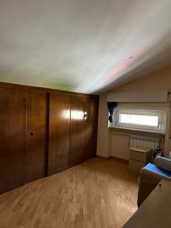 Spacious interior of a 2-bedroom penthouse apartment in Ariccia, Rome, featuring wooden closets and.