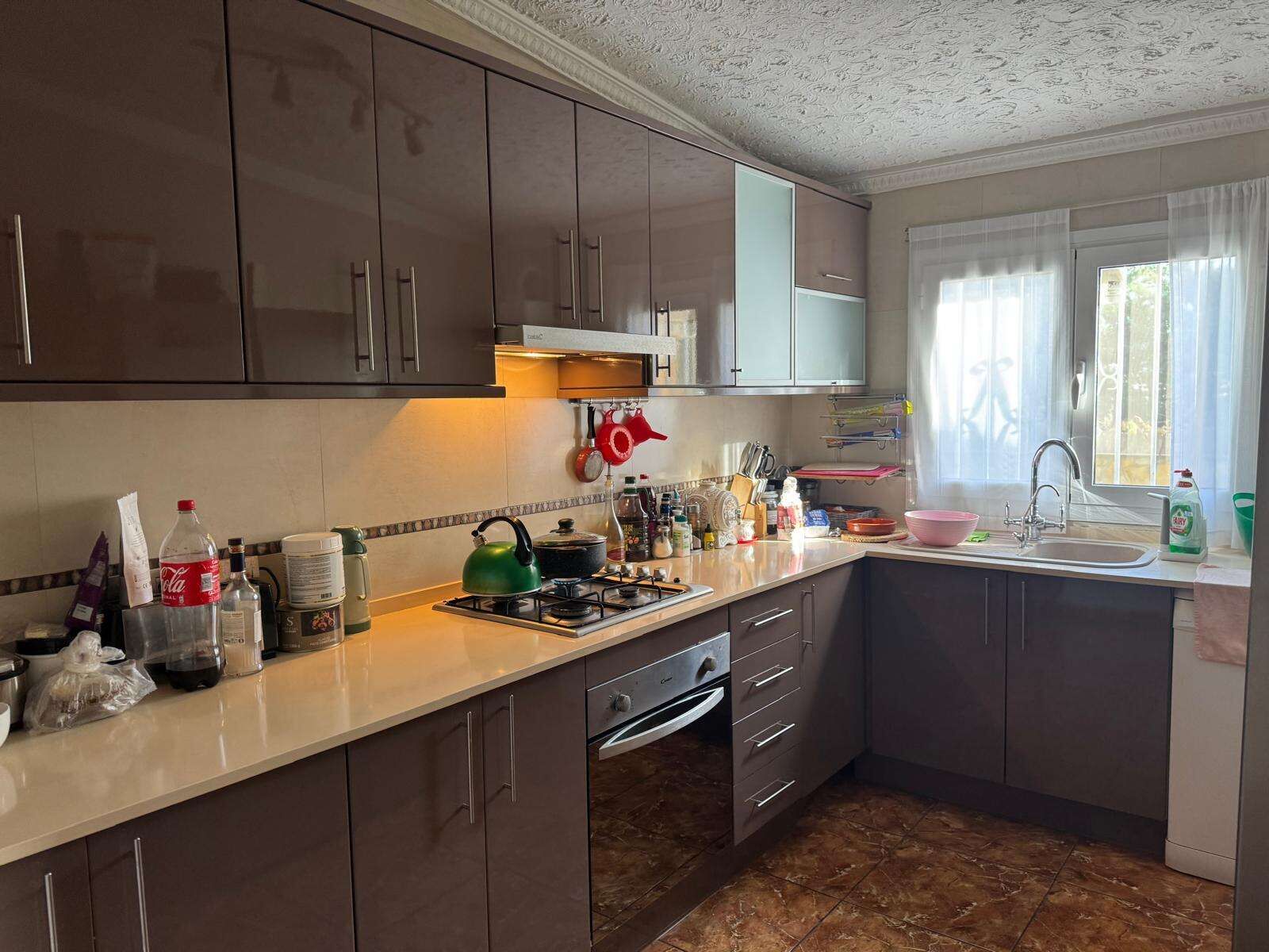 Bright, well-equipped kitchen with ample storage and natural light.