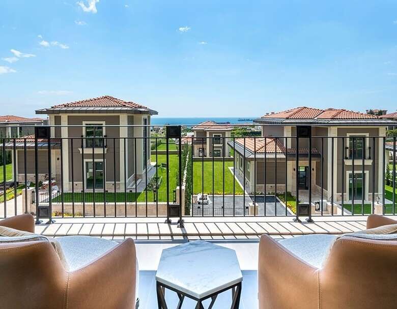 Balcony view of contemporary Istanbul apartments overlooking lush gardens and neighboring homes.