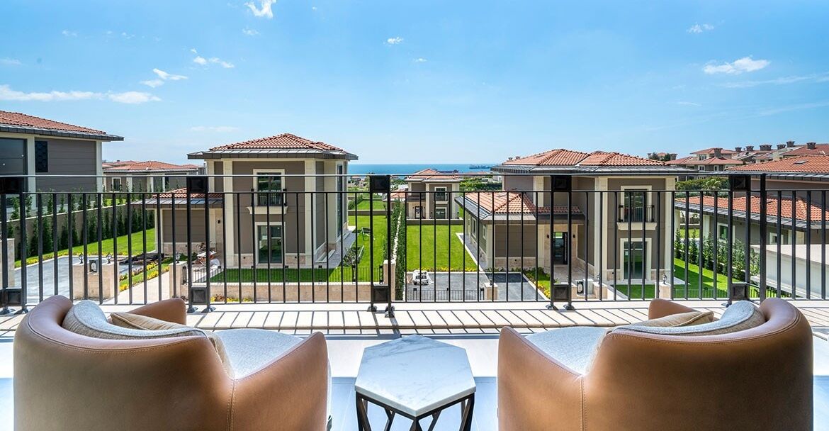 Balcony view of contemporary Istanbul apartments overlooking lush gardens and neighboring homes.